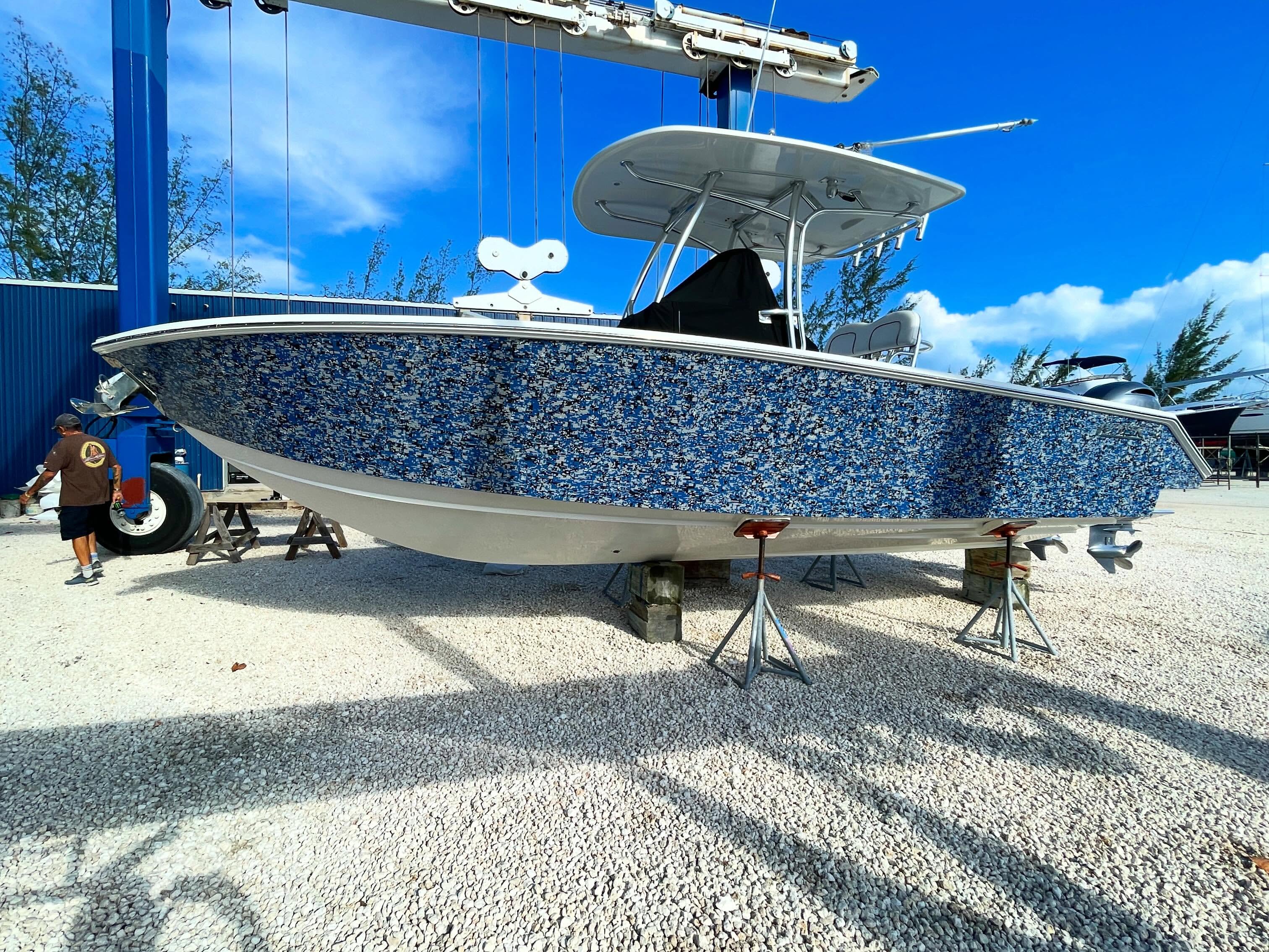 26-foot Jupiter center console with a full custom blue camo hull wrap, on stands in the Bahamas